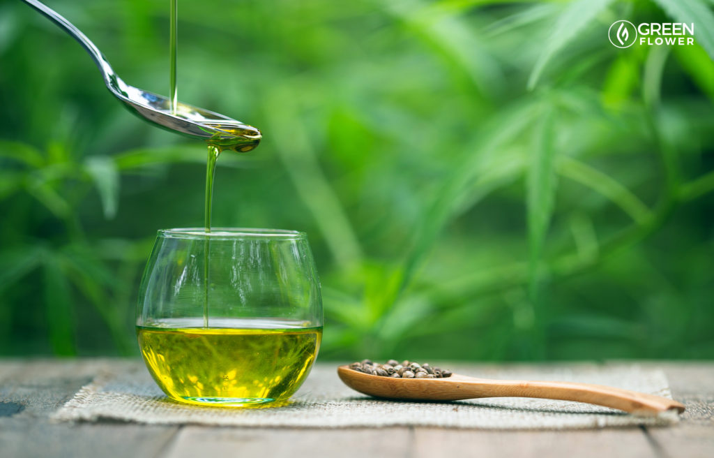 cannabis oil dripping into a cup from a spoon